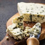 Blue cheese and knife on cutting board