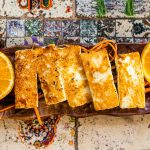 Grilled Halloumi Cheese on a plate with herbs. Top view