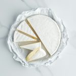 top view of camembert cheese on white marble tabletop