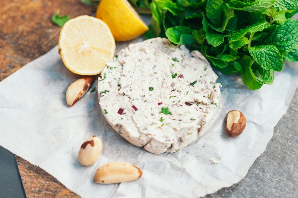 Vegan cheese on white napkin with brazilian nut, mint and lemon